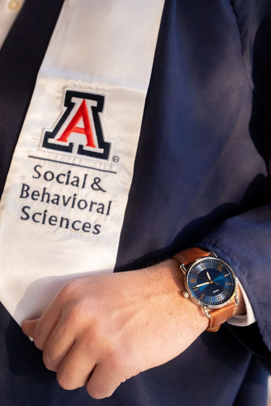 Detail of a Social & Behavioral Sciences stole and a wristwatch