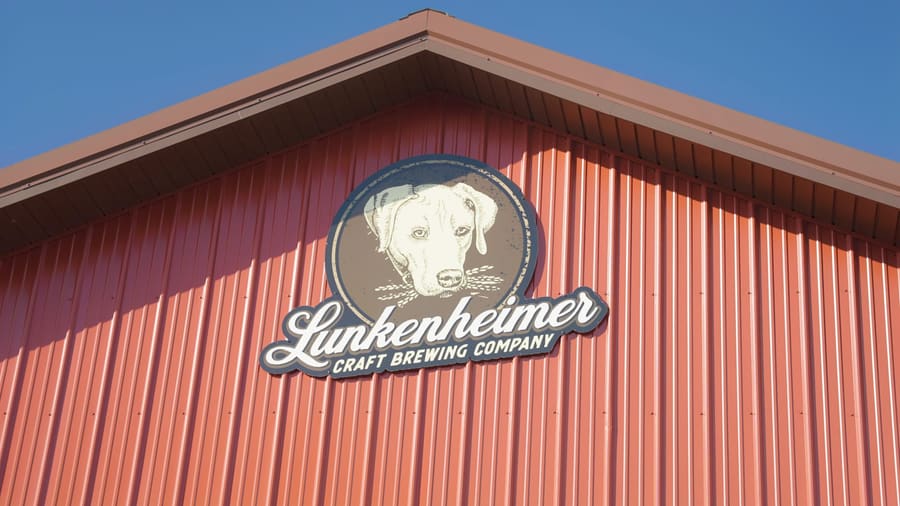Lunkenheimer logo on the brewery's red barn siding against a blue sky
