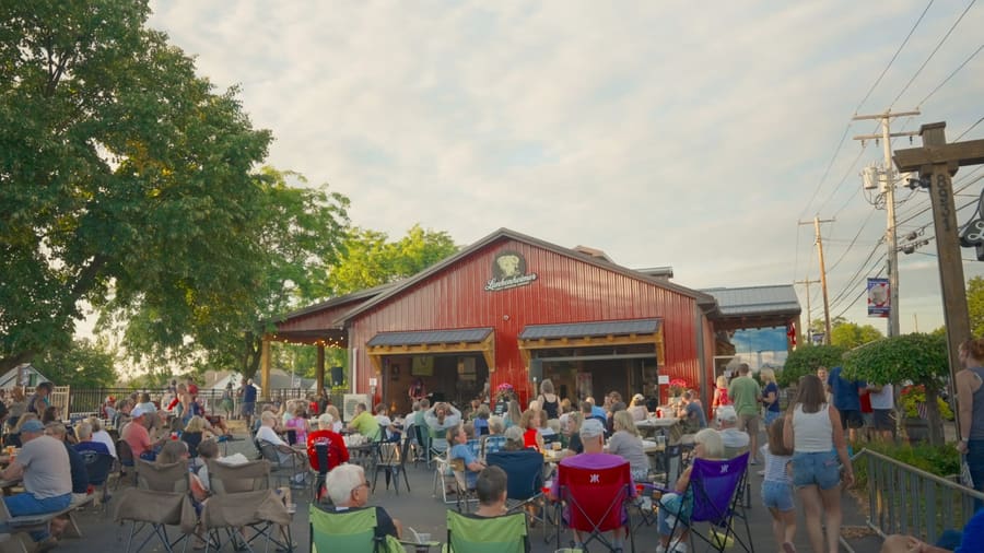 Crowd gathered in lawn chairs outside the red Lunkenheimer brewery at dusk