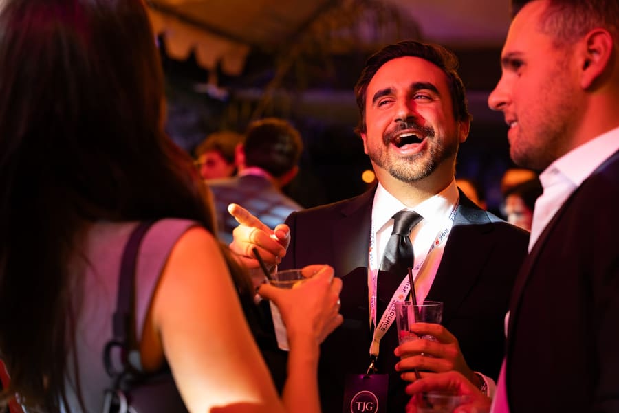 Guests in suits laughing together at an evening gala