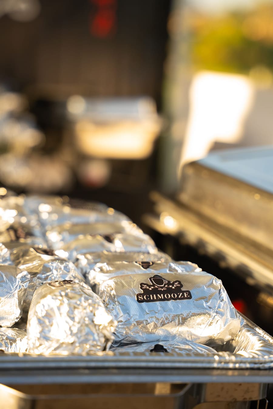 Foil-wrapped breakfast burritos lined up in a tray