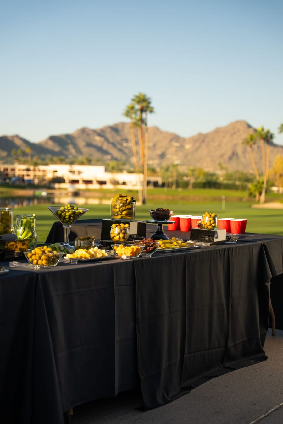 Catered spread on the course with mountains and palms behind