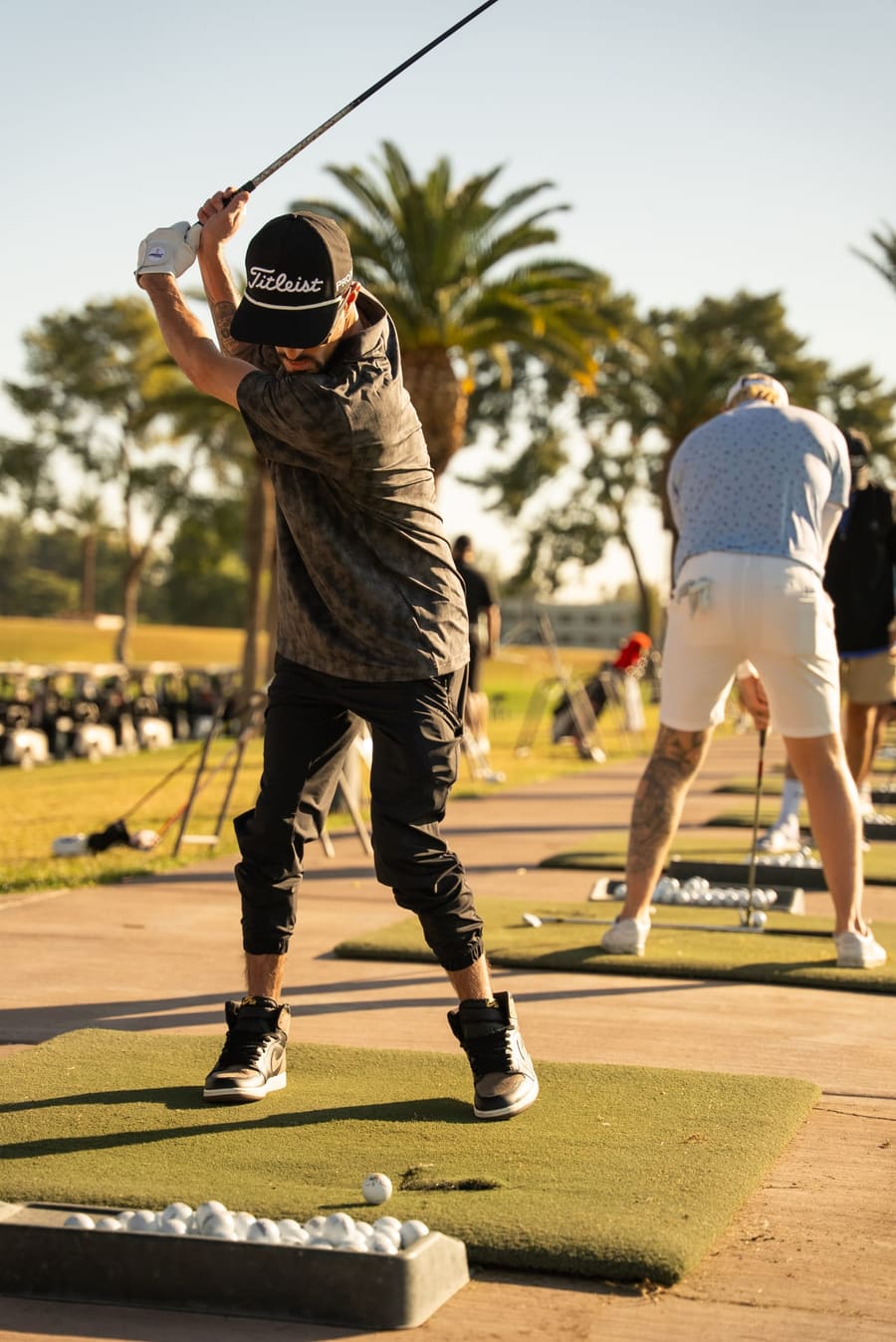 Golfer mid-swing on the driving range